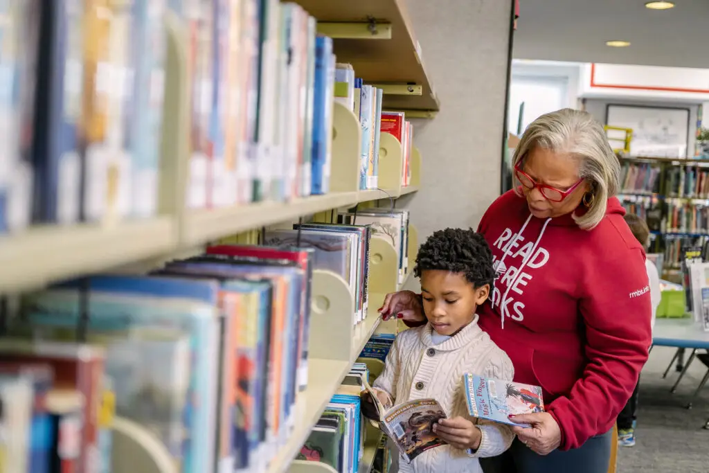 Librarian and student searching for books