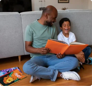father and son reading and laughing